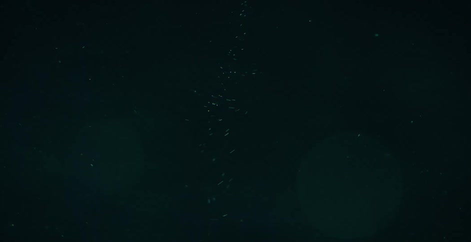 Extreme close up of air bubbles rising up and spinning on a vortex on a thick green liquid