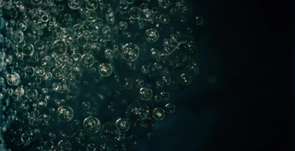 Bubbles sparkle as they float and rise in liquid