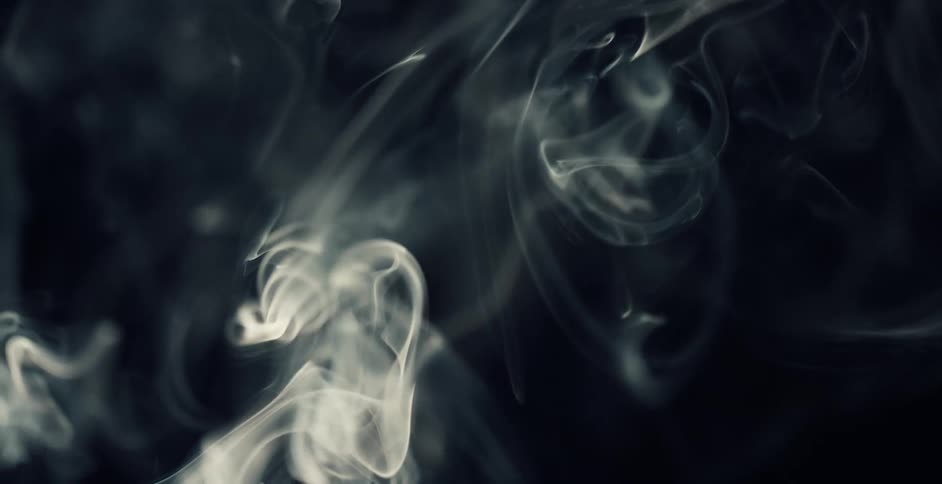 White smoke floats and rises against a black background