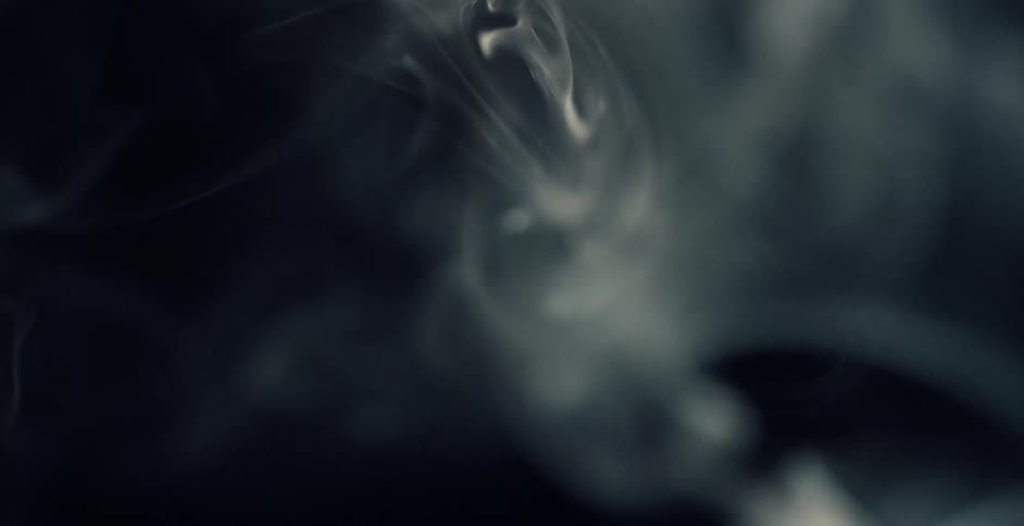 White smoke rising and swirling against a black background