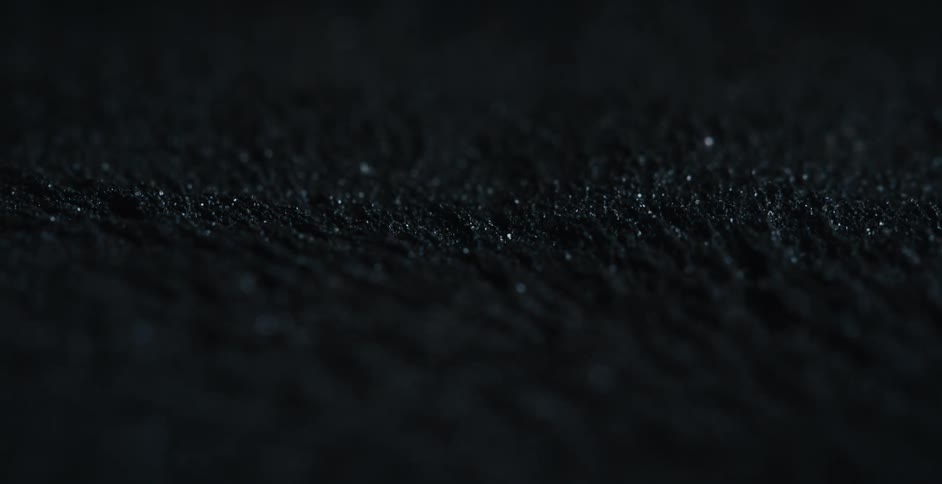 A magnetic force moves lines of black sand back and forth