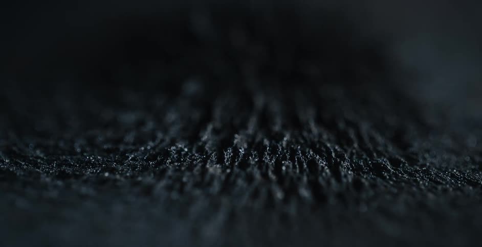 A magnetic force moves grains of sand in a pattern up and down