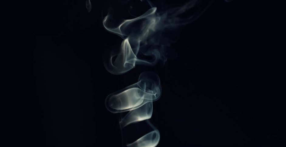 A ribbon of smoke rising and swirling against a black background