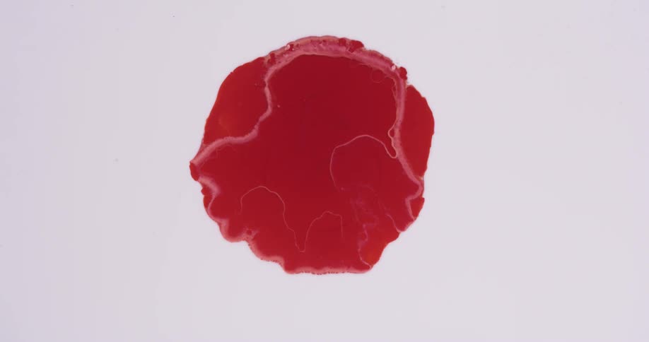 A red circle of dye in liquid shifts with edges folding inward
