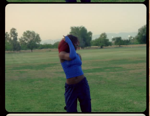 A woman is dancing in uniform in a park