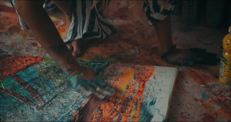 A woman finger paints on a canvas