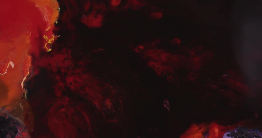 Red and black paints combine together to create a swirl pattern