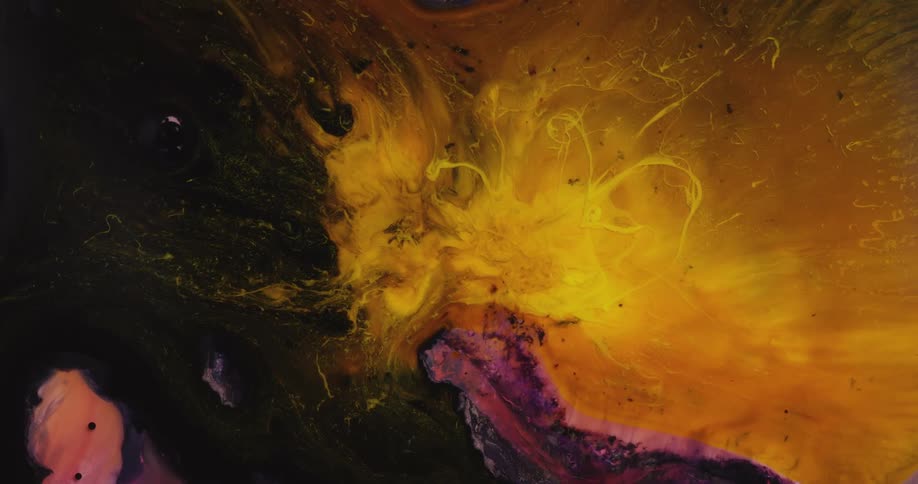 Bright yellow liquid ink blooms in strands swirling over a black background