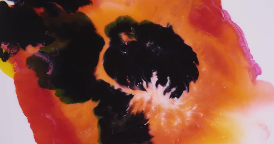 Black colored fluid spreads through mixture of red fluids overtaking the white at the center