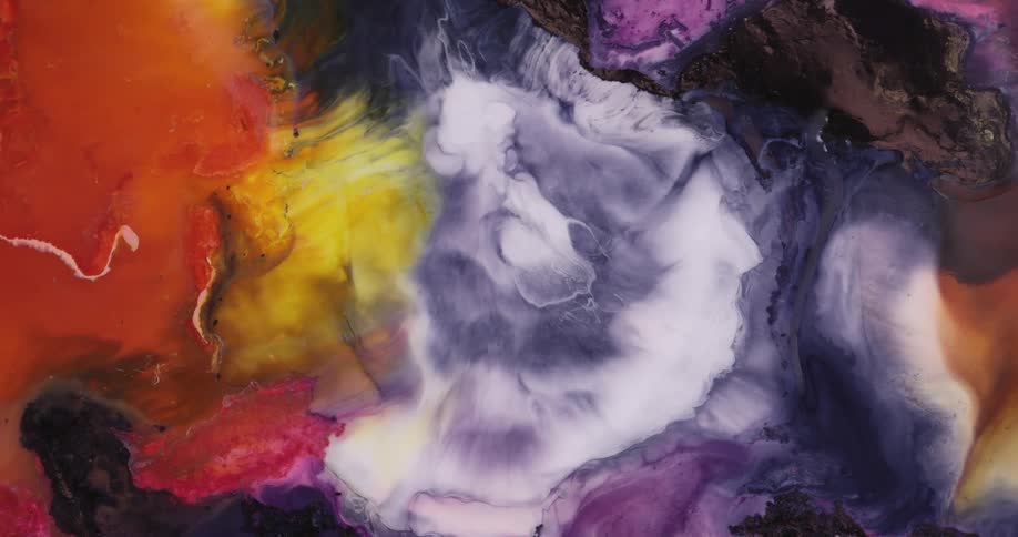 Bright yellow and red liquid ink mixing with dark blue swirling over a white background