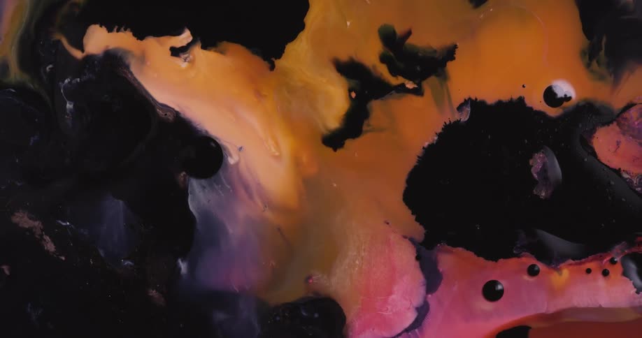 Dark liquid ink blooms mixing with surrounding red and yellow ink
