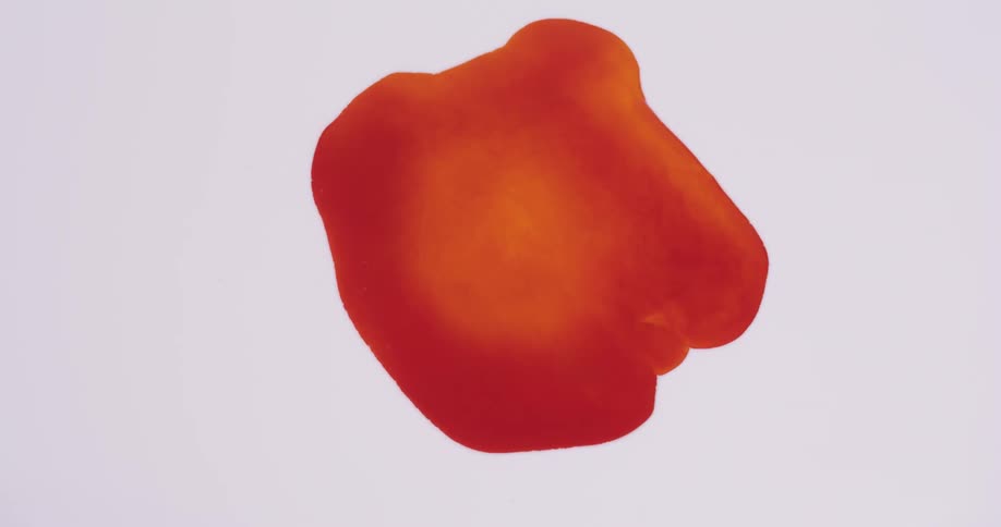A spot of red liquid expands and grows larger