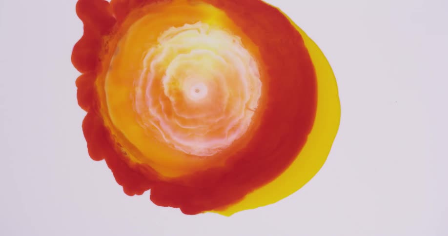 Red yellow and white paint colors flow out in a circle explosion like movement