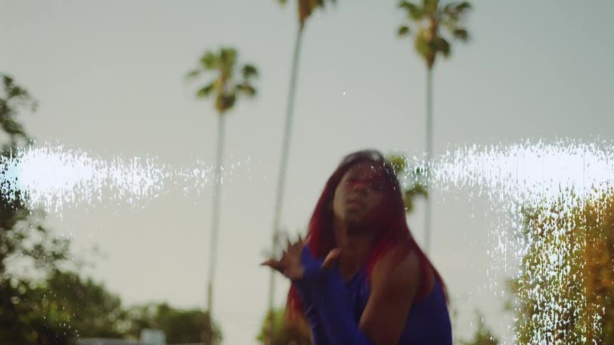 A teenage girl wearing a blue outfit is outside dancing on a neighborhood street