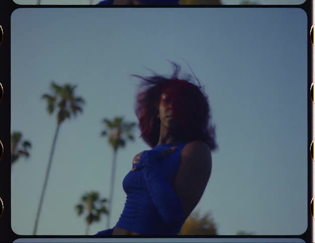 Female dancer dances outdoors with trees in the background