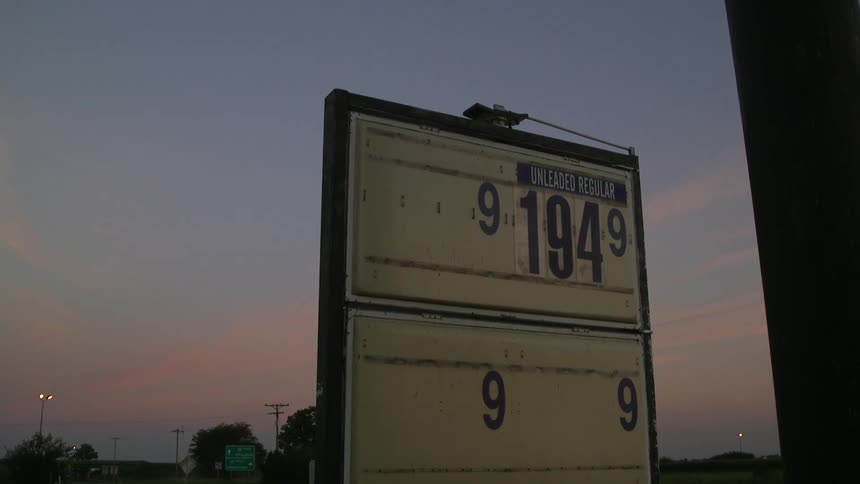 A gas station sign at sunset