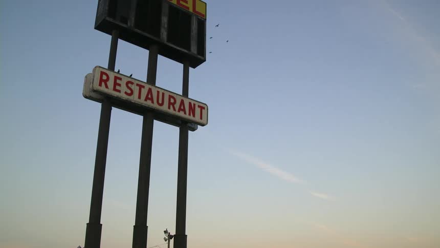 Birds fly around a sign that says restaurant