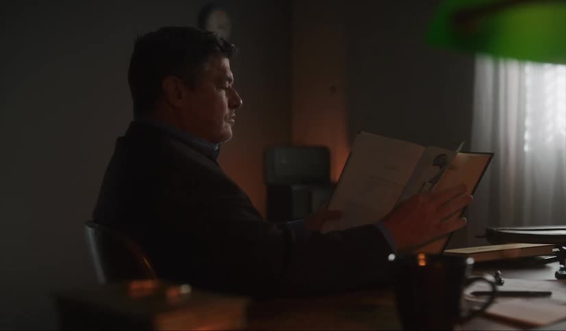 A man sits and reads in his office