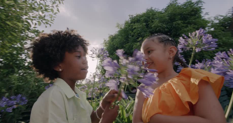 Friend teases another girl with a flower causing her to laugh