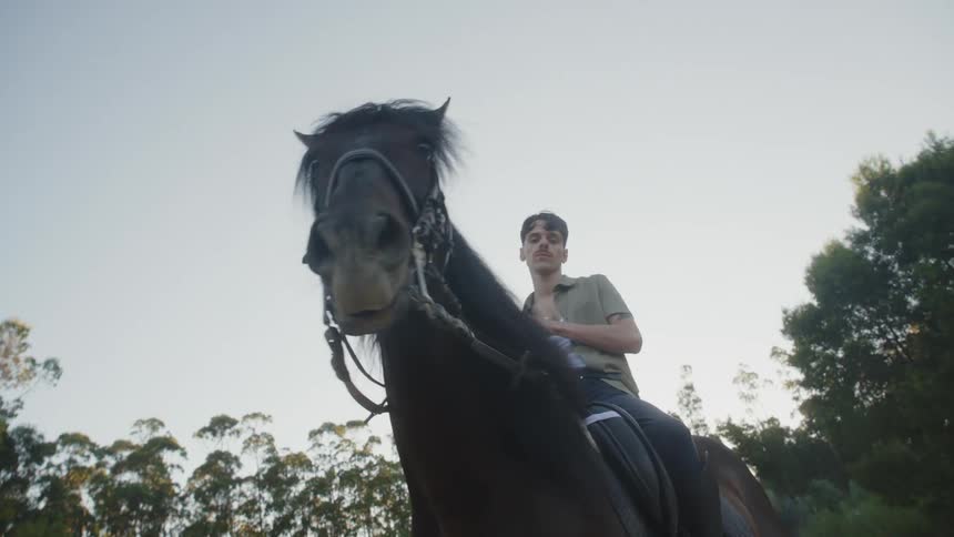 A man poses on top of his horse