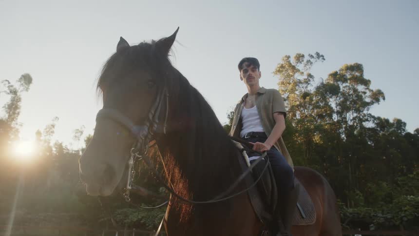 A man poses on top of his horse