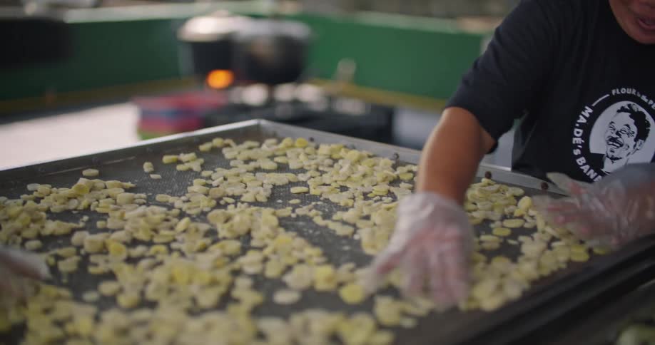 Two people sort food on a tray