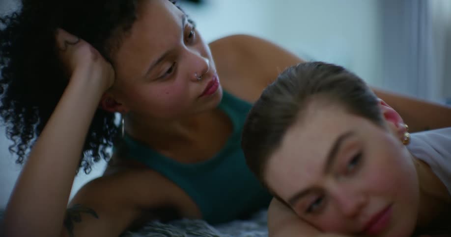 Young woman looks at her partner while lying on the floor at home
