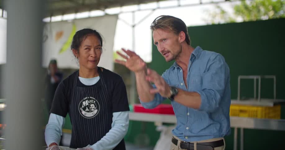 Man and woman are preparing food together outdoors