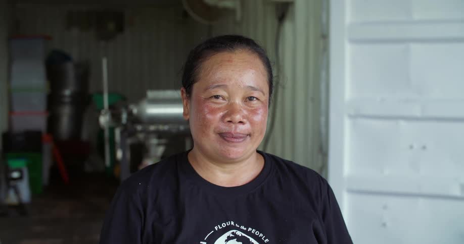 A woman with a sunburned face is standing near a door smiling