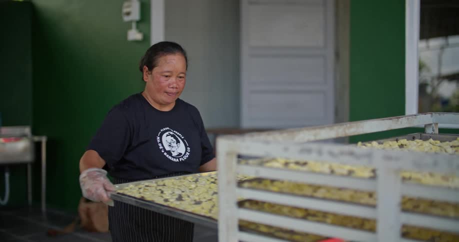 A woman puts a tray of food on the rack