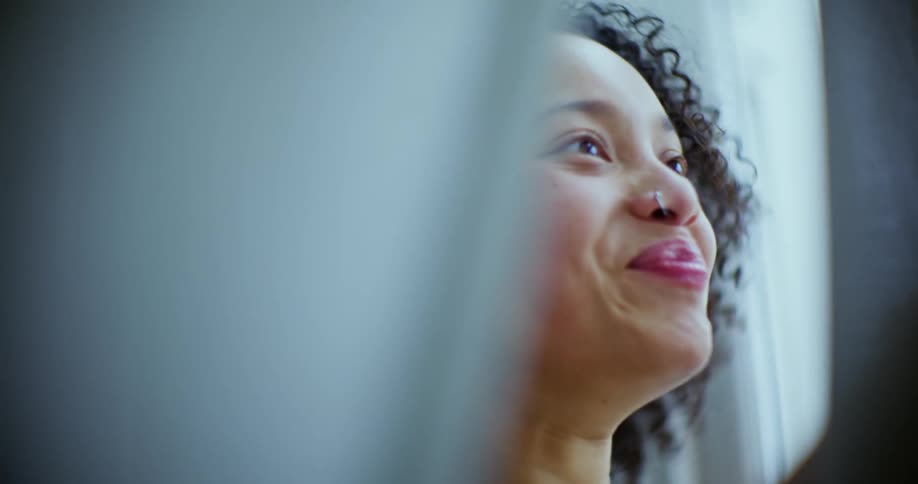 A woman looking out a window and laughing