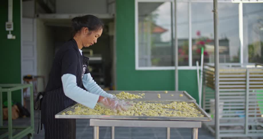 A woman is sorting food on the tray
