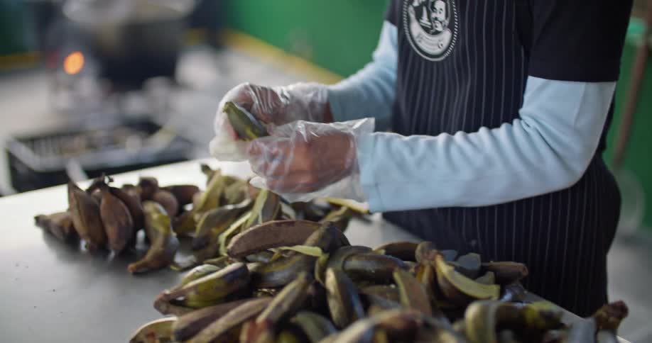 A person peeling bananas in a restaurant