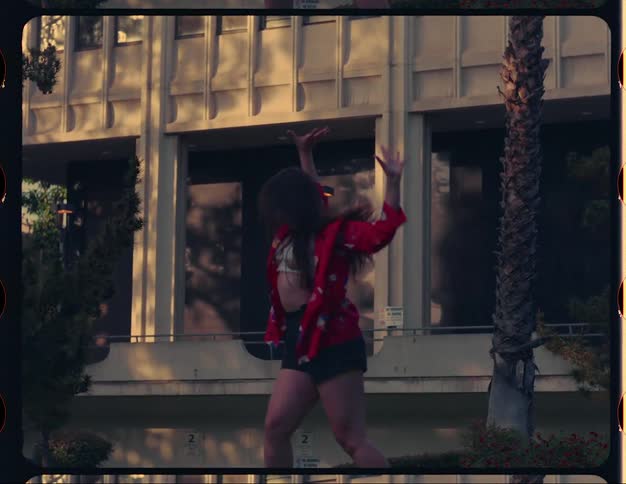 Female dancer dances outdoors near building