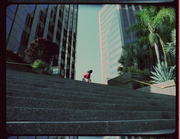 A woman is dancing outdoors in a downtown city