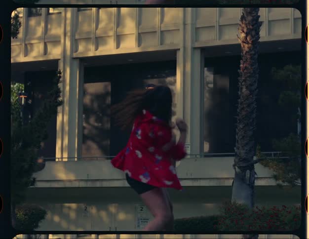A woman is doing a crazy interpretive dance in front of a building