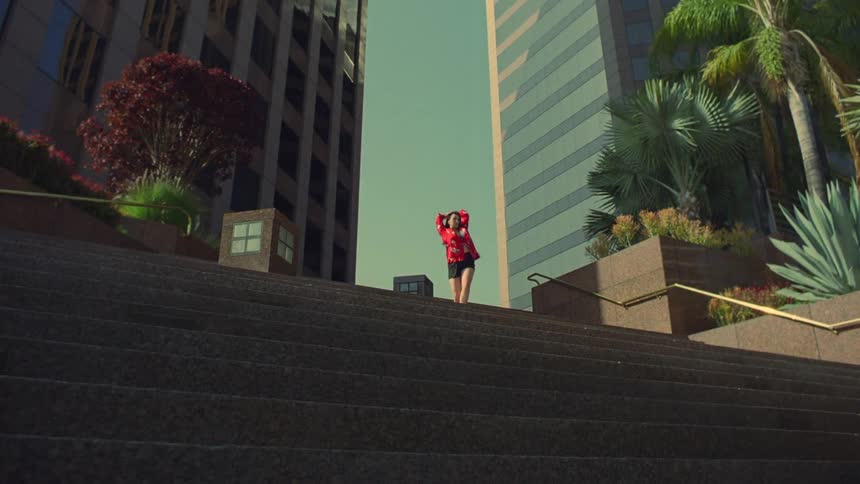 A woman is dancing on the top of the stairs