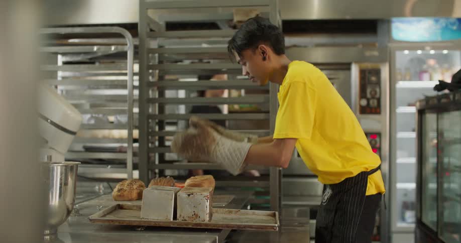 Co workers are cooking food in the kitchen of a restaurant