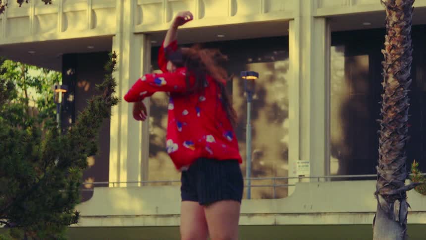 A woman is dancing by the building