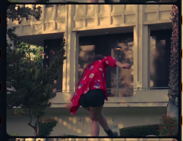 A woman dances while standing downtown