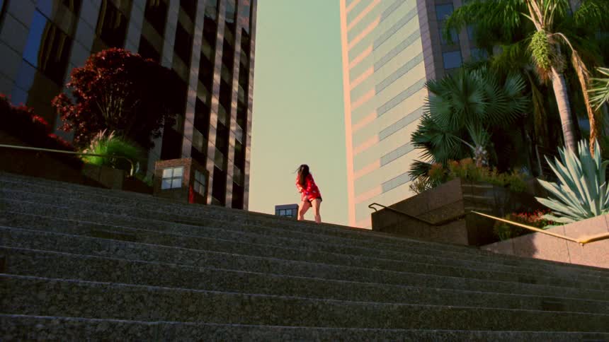 A woman is dancing outdoors in an urban city