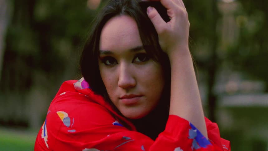 Close up of the face of a young woman wearing a colorful red jacket outdoors