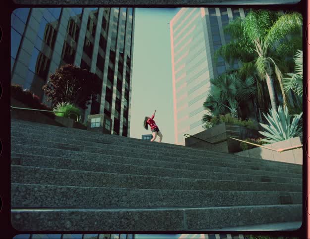 A woman dances on top of steps downtown