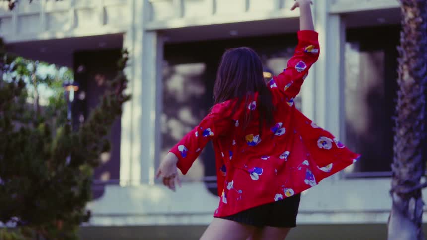 A woman dances outdoors during the day