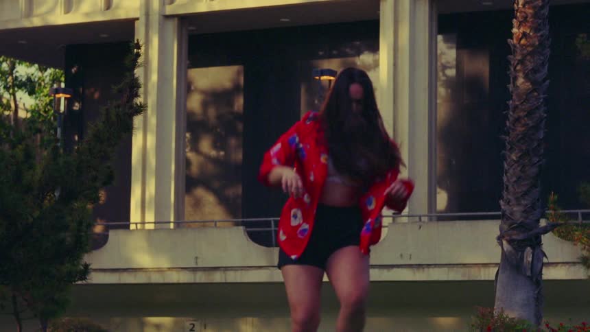 A woman dances outdoors during the day