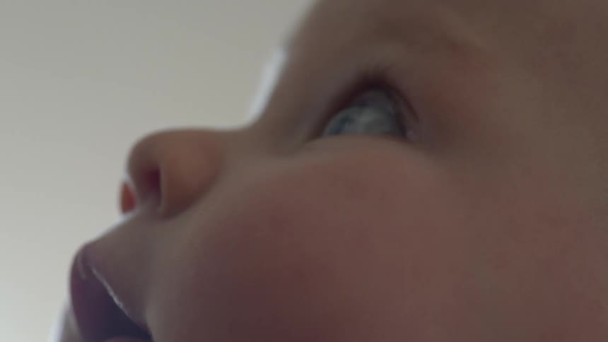 A babys eyes gleam as they look up and around