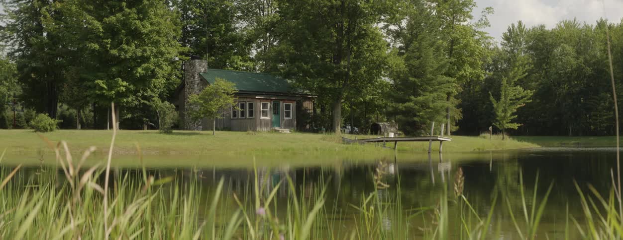 A house sits near a lake with a pier