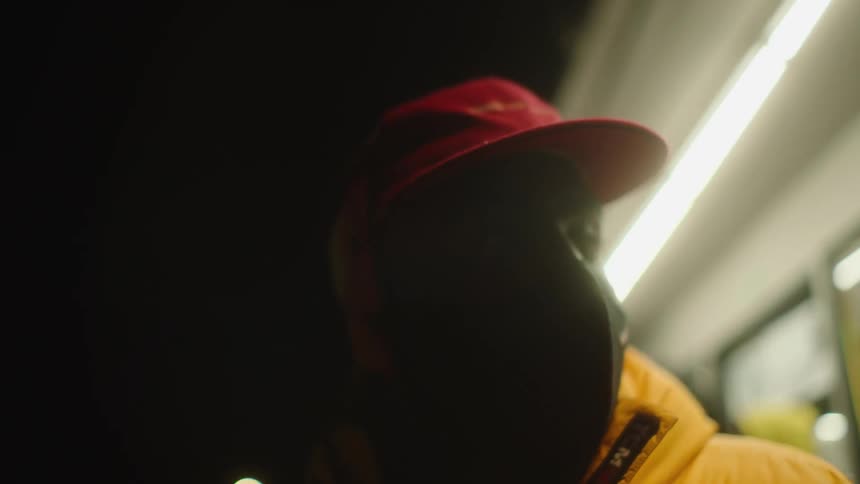 A man stands outside of a business at night