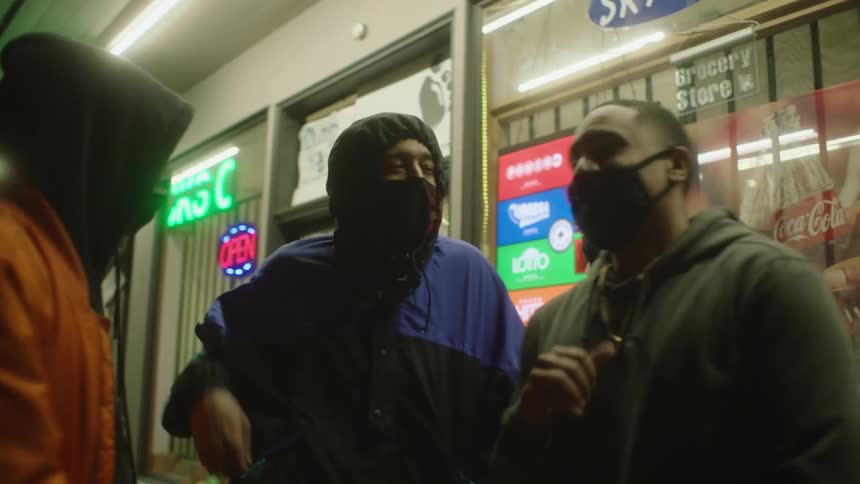 A group of men wearing medical masks are standing outside a store