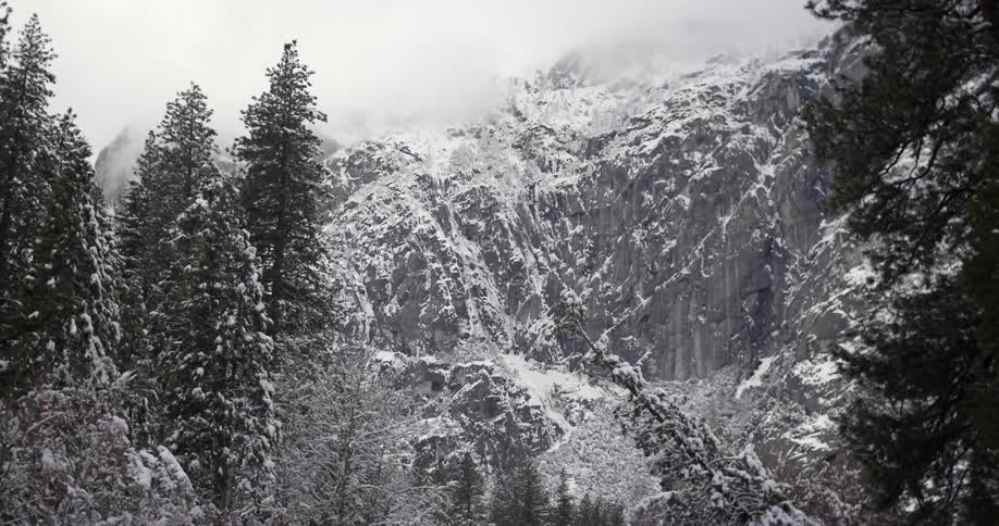 A snowy mountain top is covered in clouds